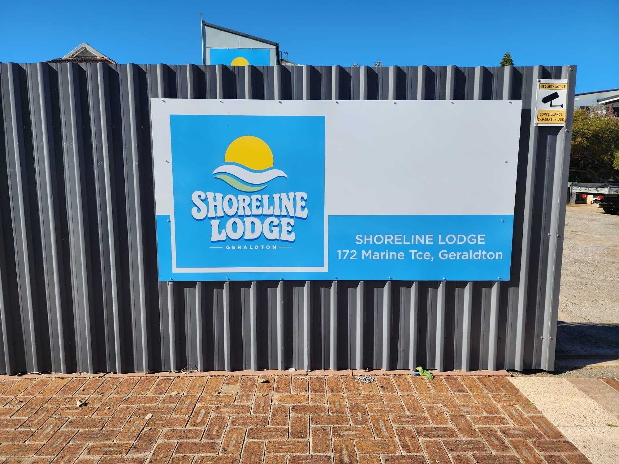Señal de Shoreline Lodge con una vista clara de la dirección.