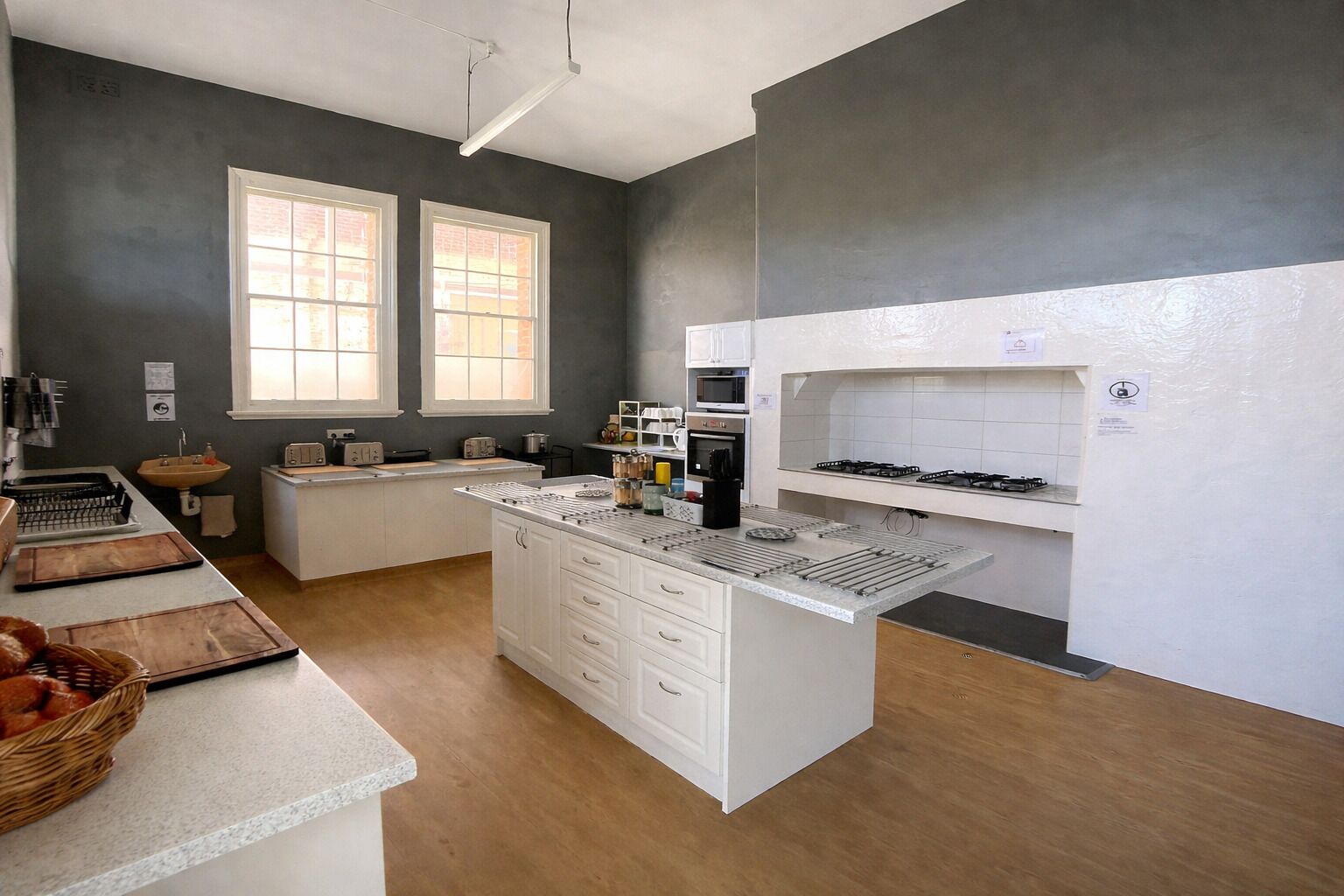 Una cucina moderna con mobili bianchi, un'isola centrale e un piano cottura a gas.