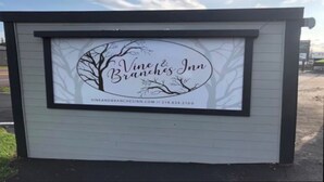 A sign for Vine & Branches Inn with a tree and leaf design. - #6 King- View of Lake Superior, 2 minute walk to Burlington Bay! (Two Harbors)