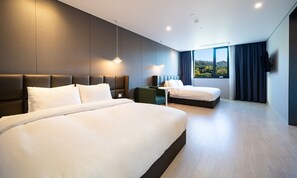 A modern hotel room with two large beds, a small table, and a view of the outdoors. - Hotel Ohevday (Namwon)
