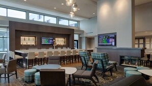 A modern bar area with seating, a fireplace, and a television. - Residence Inn by Marriott Columbus Airport (Columbus)