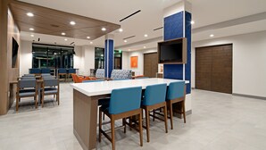 Una sala de conferencias moderna con una gran mesa, sillas azules y detalles de madera.