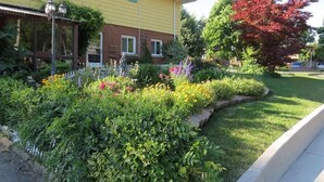 A yellow building with a garden in front. - Stunning Niagara Warm,Cozy and Clean Suite Stay (2) (Welland)