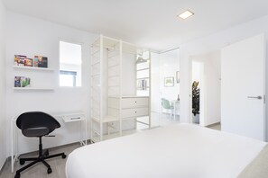 A bedroom with a bed, a desk, a chair, and a wardrobe.