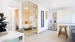 A modern apartment with a dining area, kitchen, and bedroom. - Cozy "Minimalist Apartment La Pecera" with Wi-Fi (Adeje)