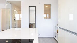 A modern kitchen with a white countertop, a built-in oven, and a small window. - Cozy "Minimalist Apartment La Pecera" with Wi-Fi (Adeje)