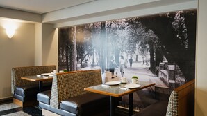 Un ristorante con posti a sedere in cabine e un grande affresco sulla parete.