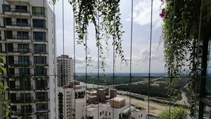 A high-rise building with multiple balconies, some with plants. - Forest City Staview Bay by Wastone (Gelang Patah)