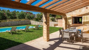 Un espace extérieur abrité comprenant une piscine, des chaises longues et une table à manger.