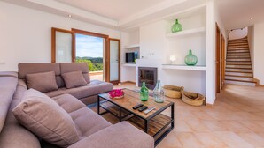 Un salon moderne avec un canapé, une table basse et une cheminée.