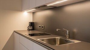 Une cuisine moderne équipée d’une cuisinière intégrée, d’un évier et d’une machine à café.