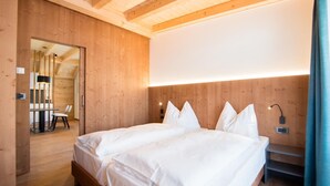 Habitació amb panells de fusta, un llit, una cadira i una taula.