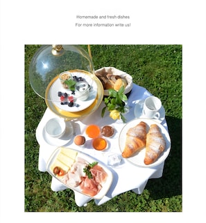 A picnic setup with a variety of food items on a white tablecloth outdoors. - 2-Room Holiday Apartment Piz da Plaies with Mountain View (San Vigilio di Marebbe)