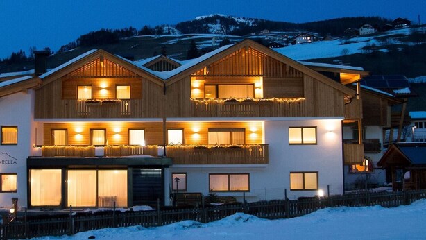 Un bâtiment en bois à deux étages, doté de nombreuses fenêtres et de balcons, et entouré de neige.