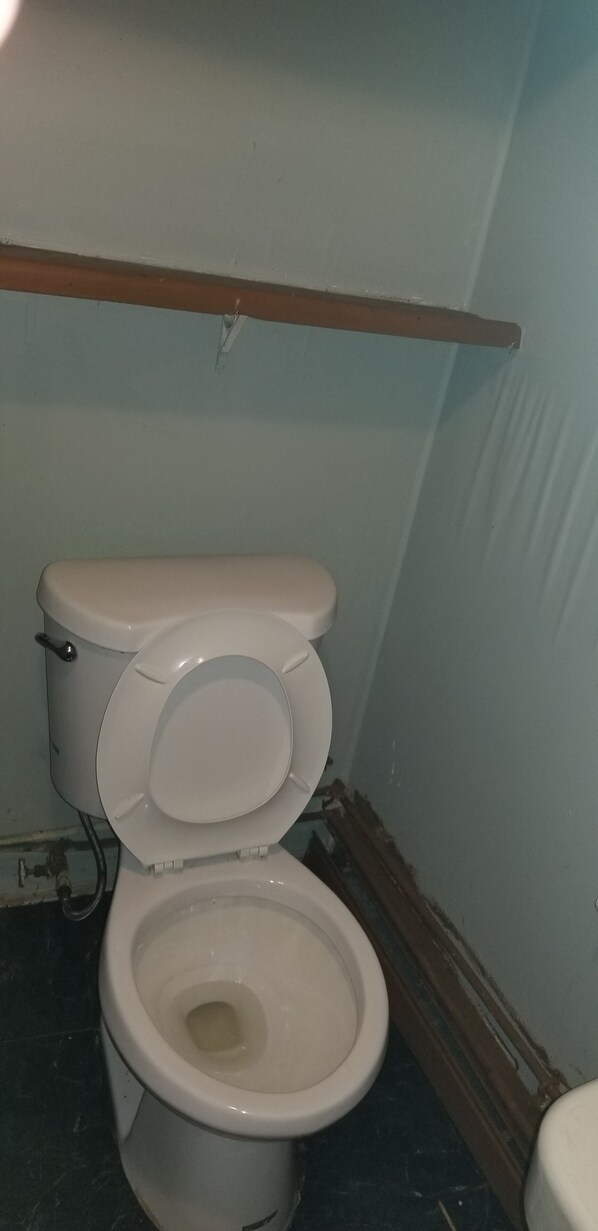 A toilet in a bathroom with a wooden beam above it. - Rustic1BRPet&420 Friendly2.5blocksToBoardsSeptSpecialsProm&SeniorWks22Under25ok (Wildwood)