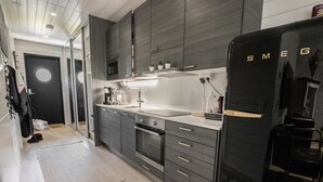 A modern kitchen with grey cabinetry, a black refrigerator, and a microwave.