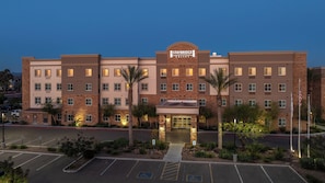 A Staybridge Suites hotel with a brick facade, multiple windows, and a parking lot. - Staybridge Suites Phoenix East - Gilbert, an IHG Hotel (Gilbert)