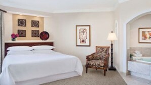 A hotel room with a bed, a chair, a lamp, and a bathroom with a bathtub. -   $899/OBO, 2 Br/2Ba for 8, Balc, Kit (Orlando)