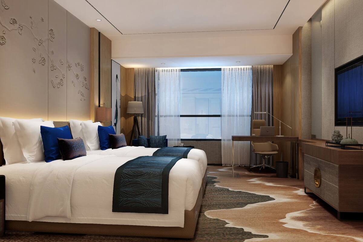 Una habitación de hotel moderna con una cama grande, un escritorio y una televisión.