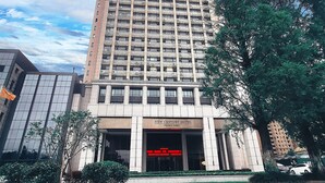 Un grand hôtel à plusieurs étages, doté d’une façade moderne, de grandes fenêtres et d’une entrée imposante.