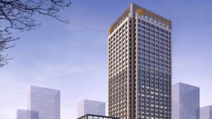 Un immeuble de grande hauteur au design moderne, comprenant de nombreux étages dotés de grandes fenêtres et d’une entrée imposante.