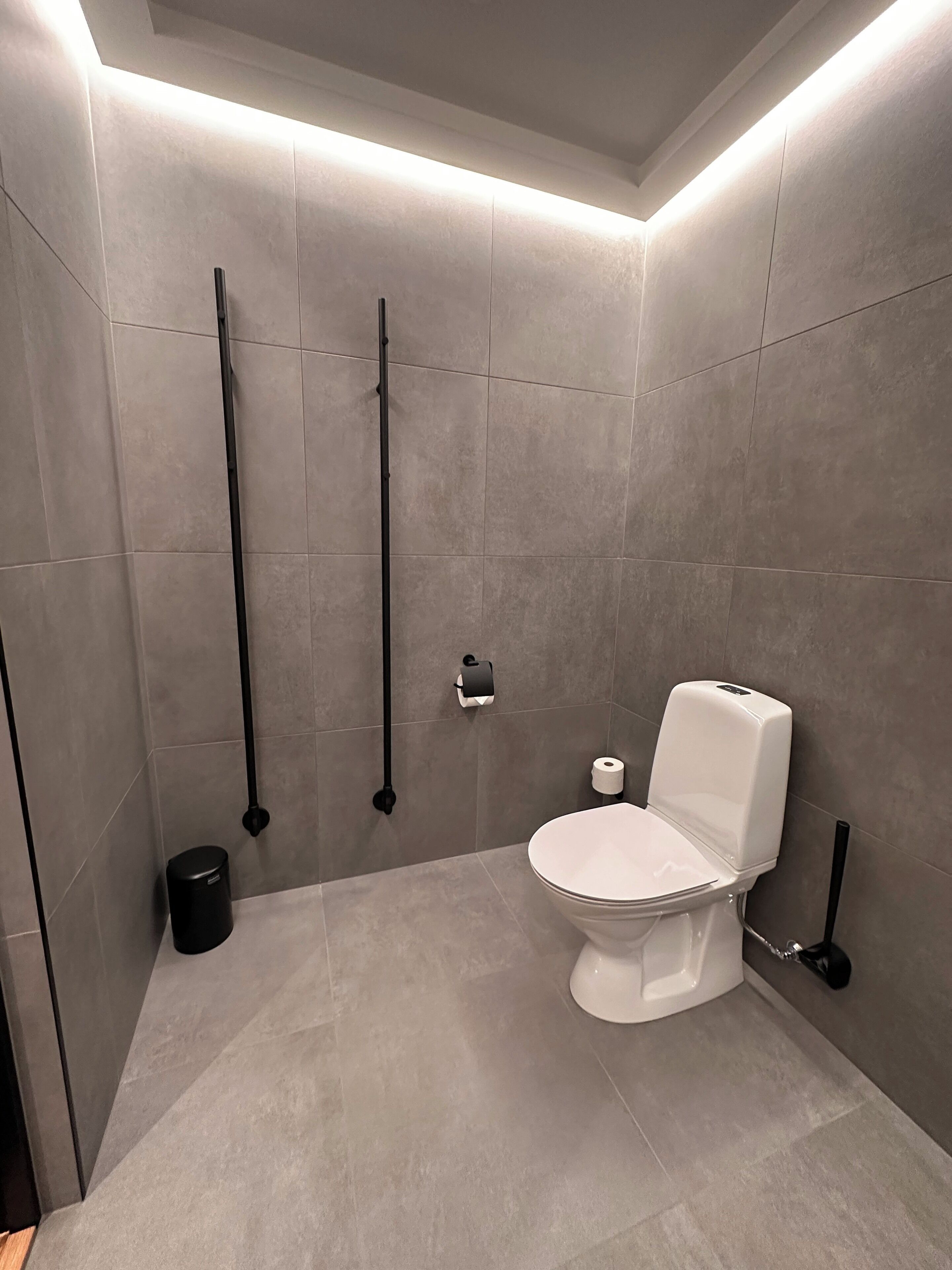 Un bagno moderno con un water, un bidet e un cestino.
