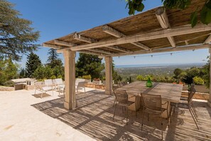 An outdoor patio with a pergola, seating, and a view of the landscape. - Villa Lemorè - Luxury villa in Puglia with seaview and private pool (Fasano)
