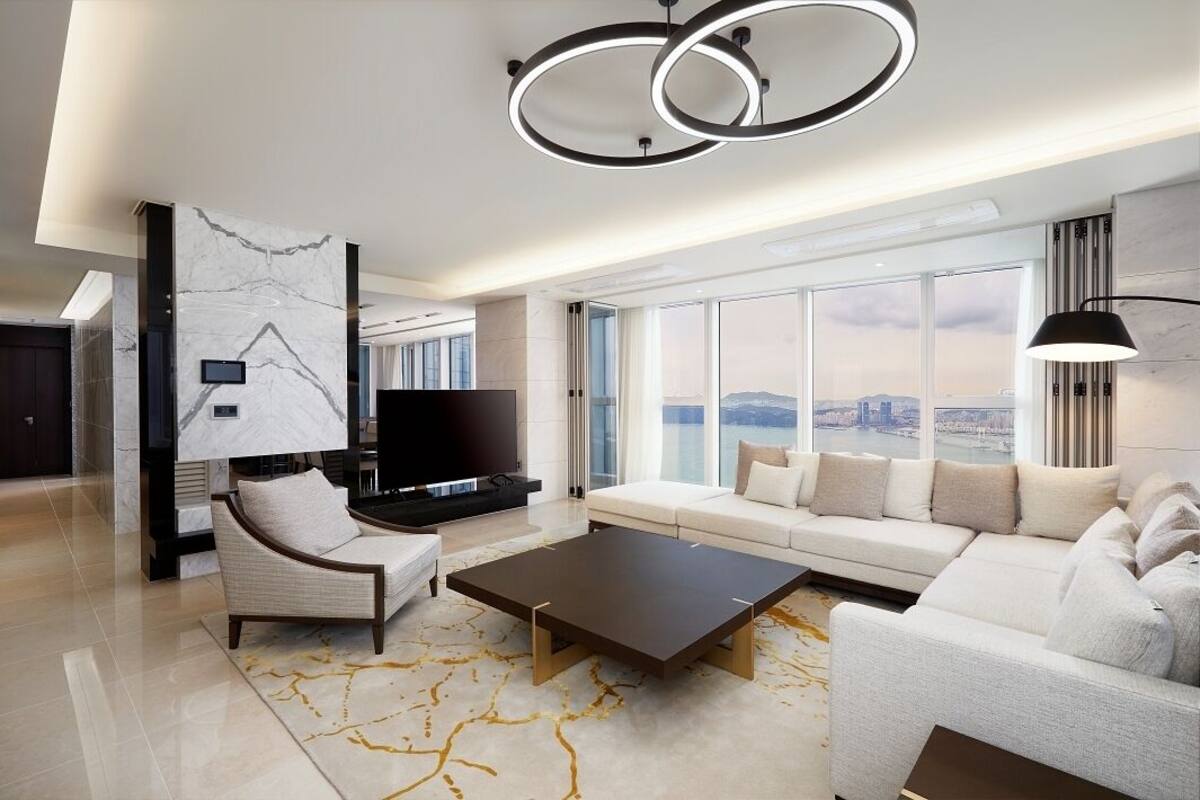 Una sala de estar moderna con sofá, sillón, mesa de centro y televisor de pantalla plana.