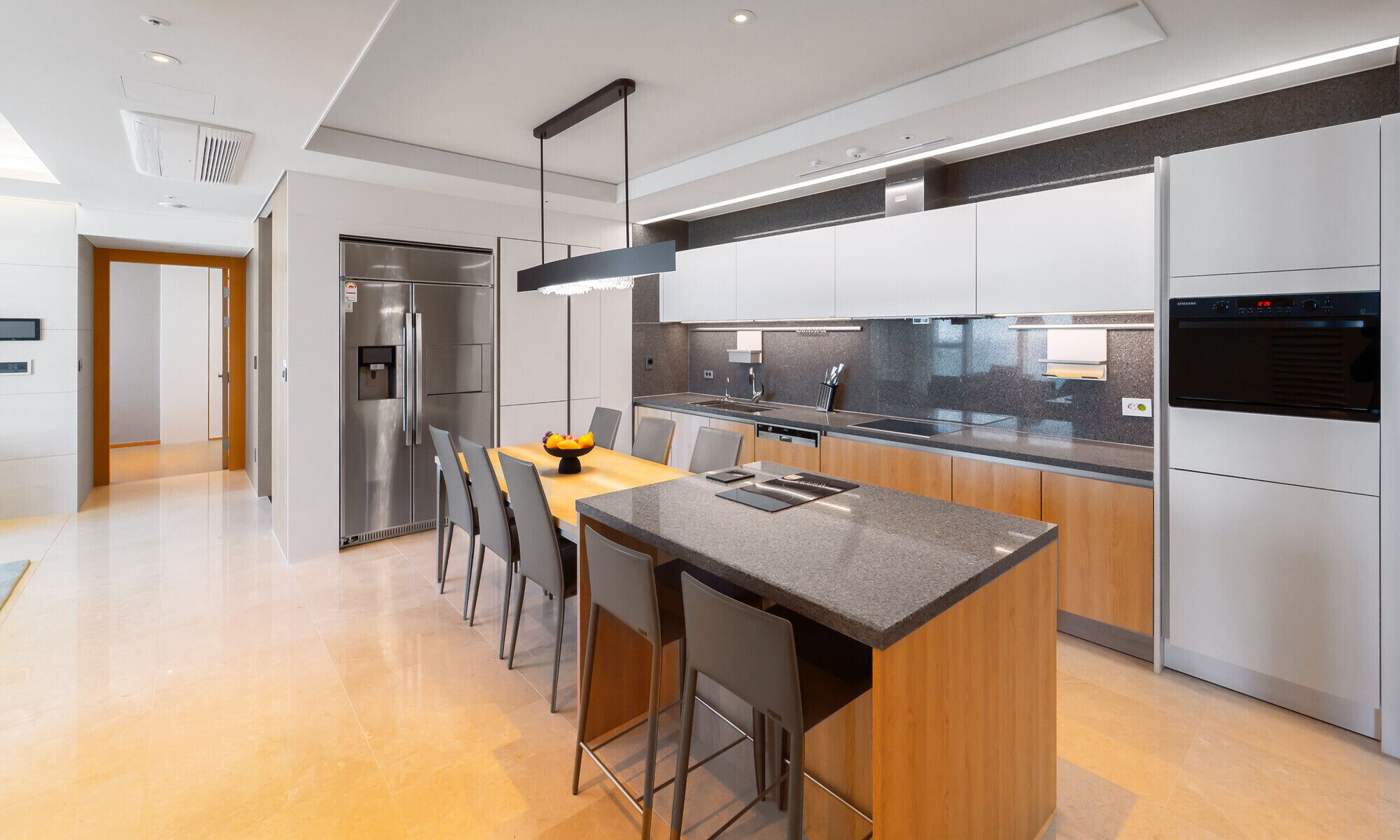 A modern kitchen with a central island, stainless steel appliances, and a minimalist design.