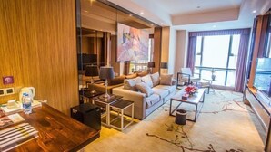 A modern hotel room with a sofa, coffee table, and a large window. - Platinum Celebrity Hotel (Chongzhou)