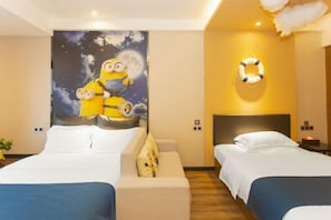 Habitación de hotel con dos camas, un mural del cielo nocturno, un adorno con forma de boia y un cabecero moderno.