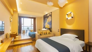 A hotel room with a bed, a desk, a chair, a sofa, and a large window. - Platinum Celebrity Hotel (Chongzhou)