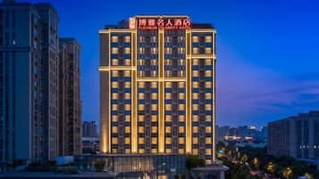 A high-rise hotel with multiple floors, large windows, and a prominent sign at the top.