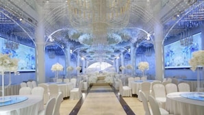 A spacious hall with a central aisle, white chairs, and tables arranged for an event. - Tiandi Renhe Luochenghui Hotel (Guanghan)