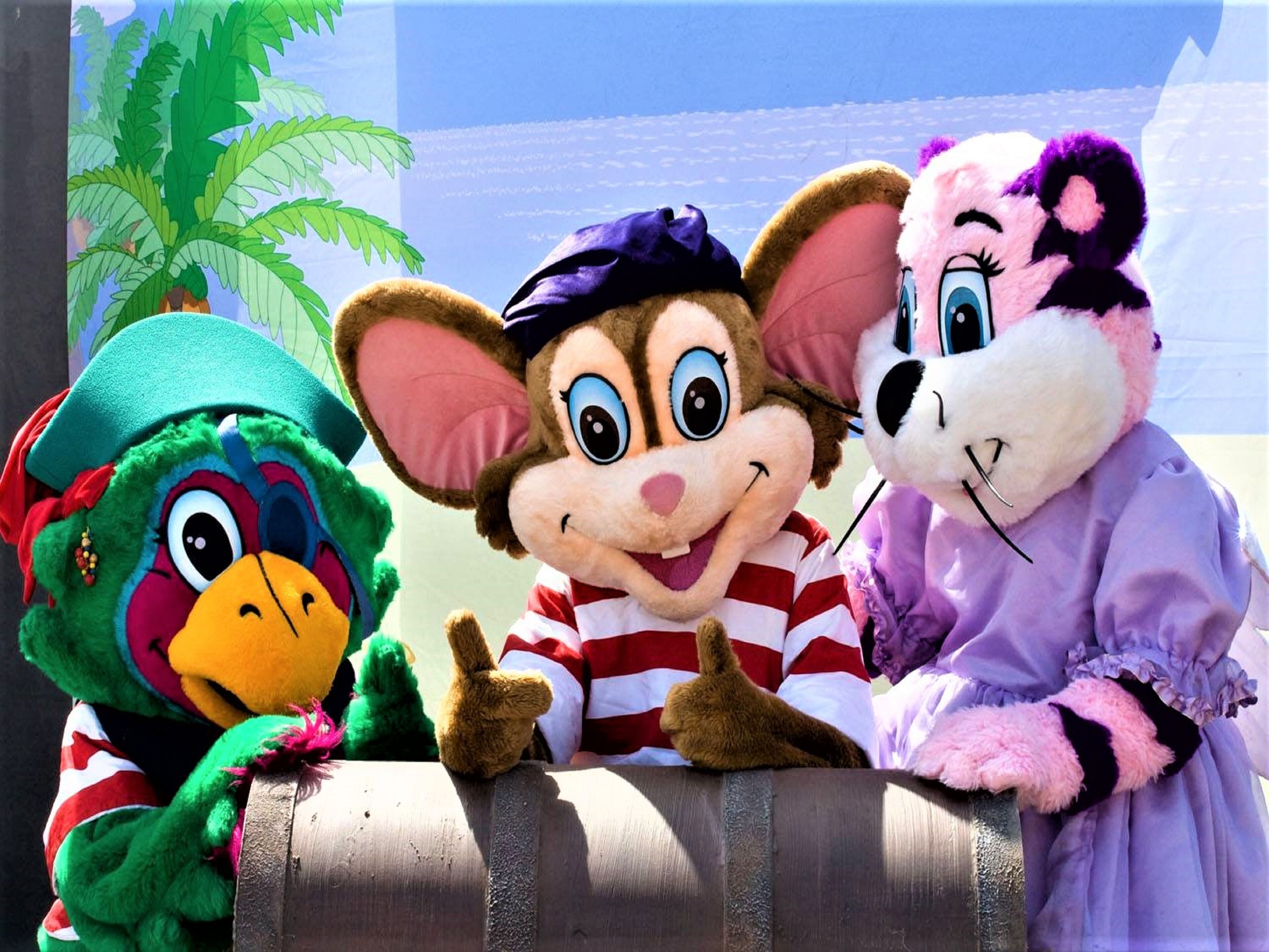 Three plush toys seated on a barrel.