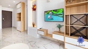 Un salon moderne doté d’un téléviseur à écran plat, d’étagères intégrées et d’un sol en marbre.
