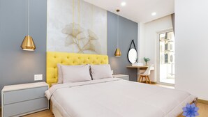Une chambre à coucher avec un grand lit, des tables de chevet, un bureau et une chaise.