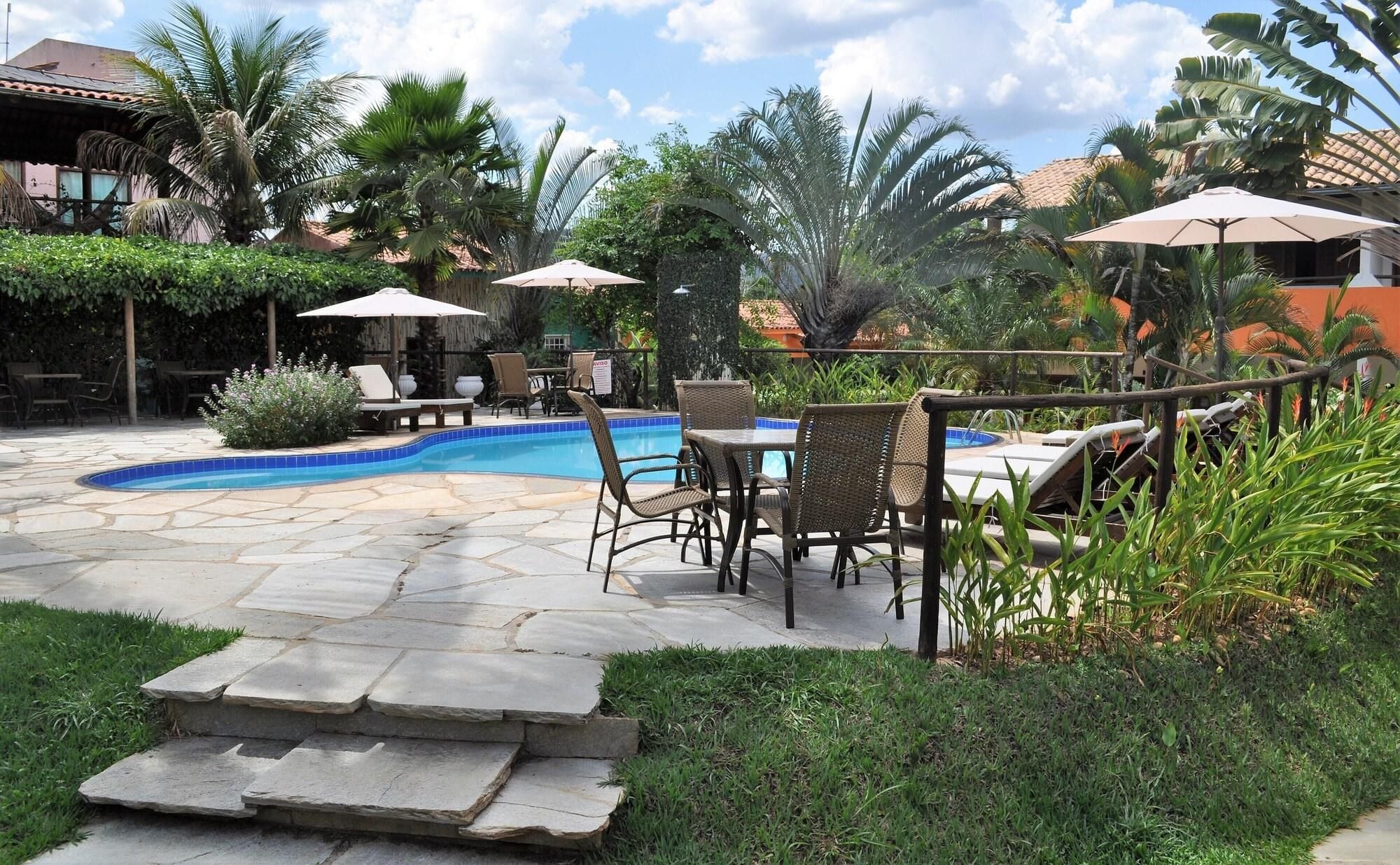 A pool area with lounge chairs, umbrellas, and a stone pathway.