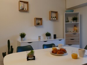 Enjoy a peaceful breakfast in this inviting dining area with a beautifully set table and lush greenery.