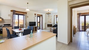 A modern kitchen with a dining area, a TV, and a fireplace.