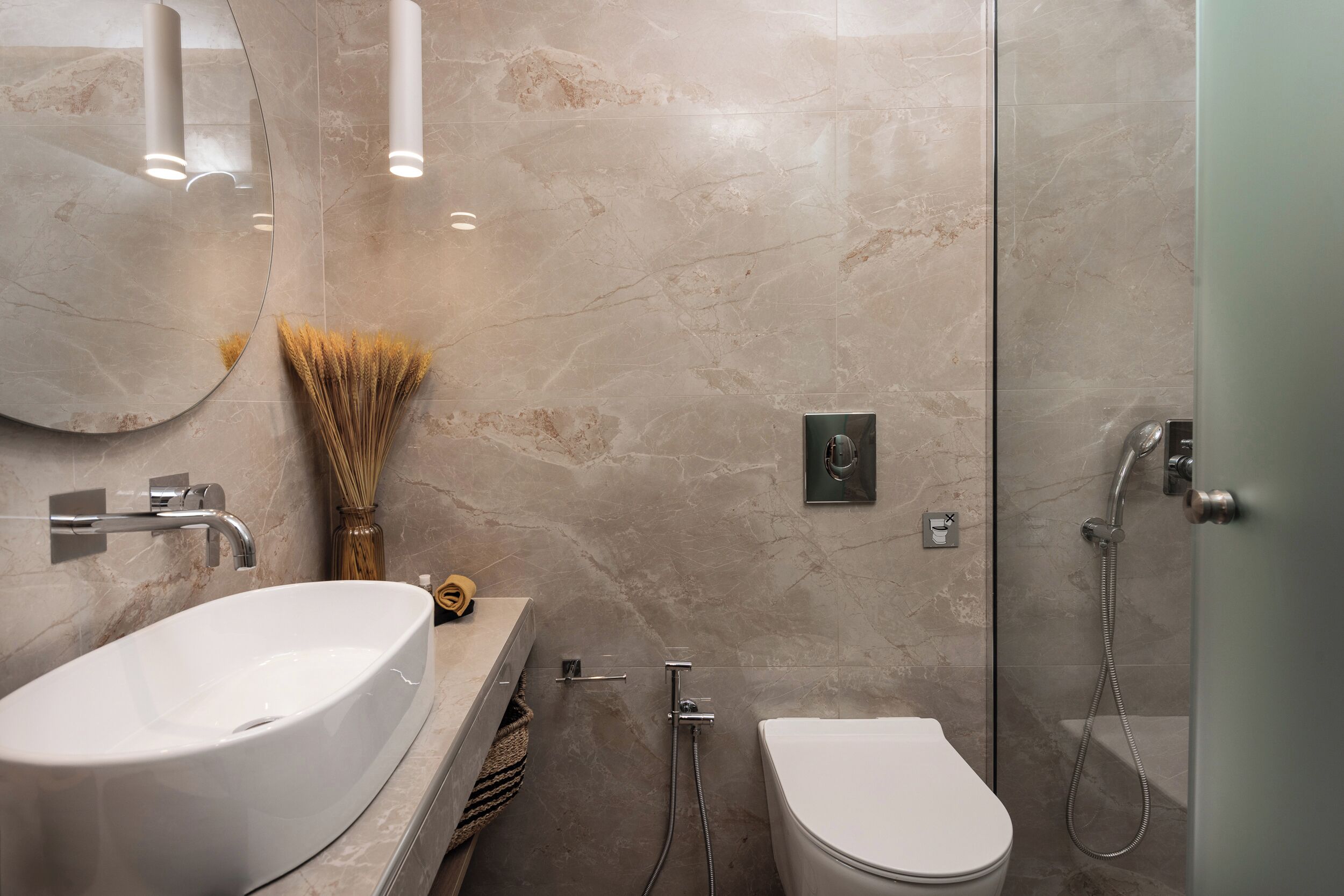 A modern bathroom with a large oval sink, a toilet, and a shower area.