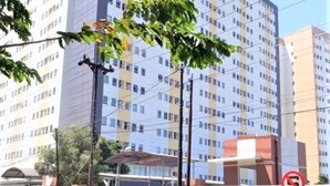 A multi-story residential building with a modern architectural design, featuring a uniform facade with evenly spaced windows and a central entrance. - Apartement Puncak Permai Tower A by Nur Faizah (Surabaya)