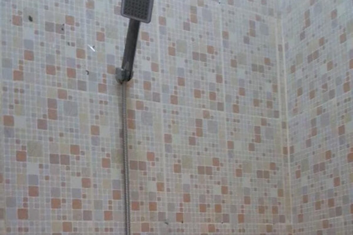 A shower with a handheld showerhead and a wall-mounted faucet.
