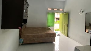 A small, clean room with a bed, a desk, and a wardrobe. - Wisma Adhyaksa 2 (Makassar)