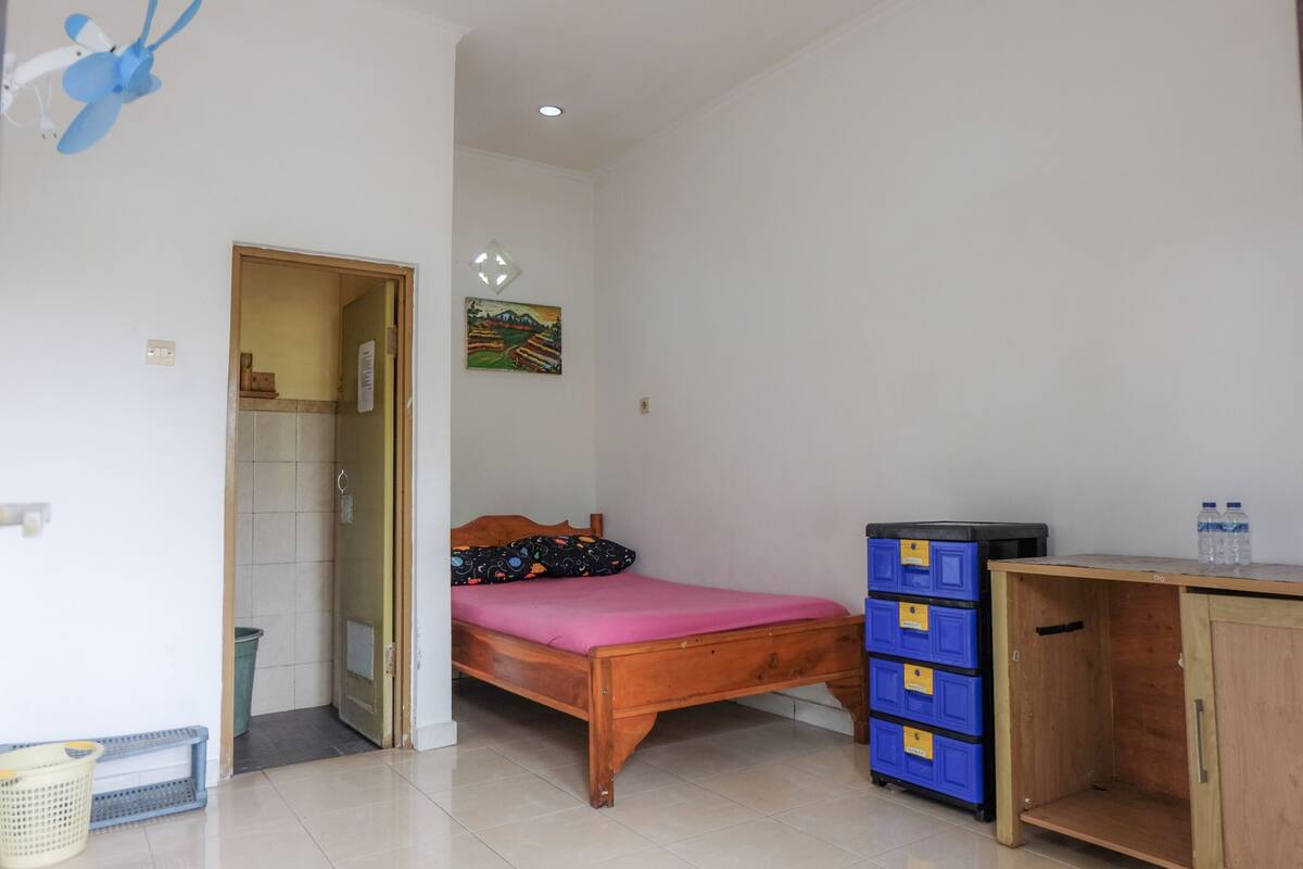 A bedroom with a wooden bed, a blue storage unit, and a wooden cabinet.