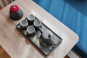 A tray with a teapot and four cups on a wooden table. - Holiday Inn Express Dali Xiaguan by IHG (Dali)