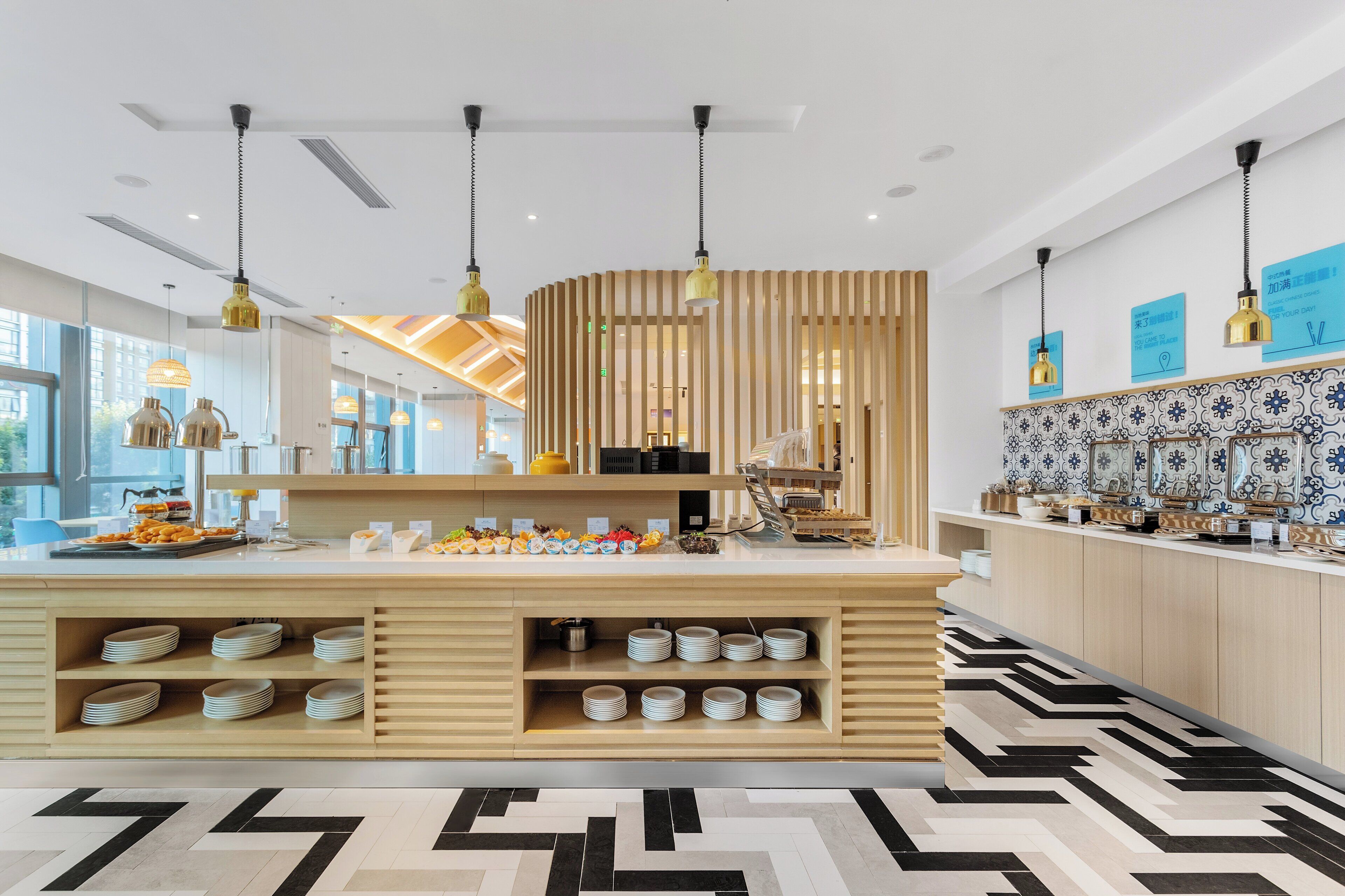 A modern kitchen with a central island, pendant lighting, and a patterned floor.