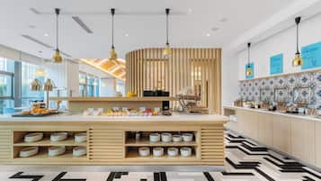 A modern kitchen with a central island, pendant lighting, and a patterned floor.