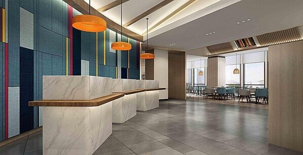 A modern reception area with marble counters, colorful vertical panels, and orange pendant lights.
