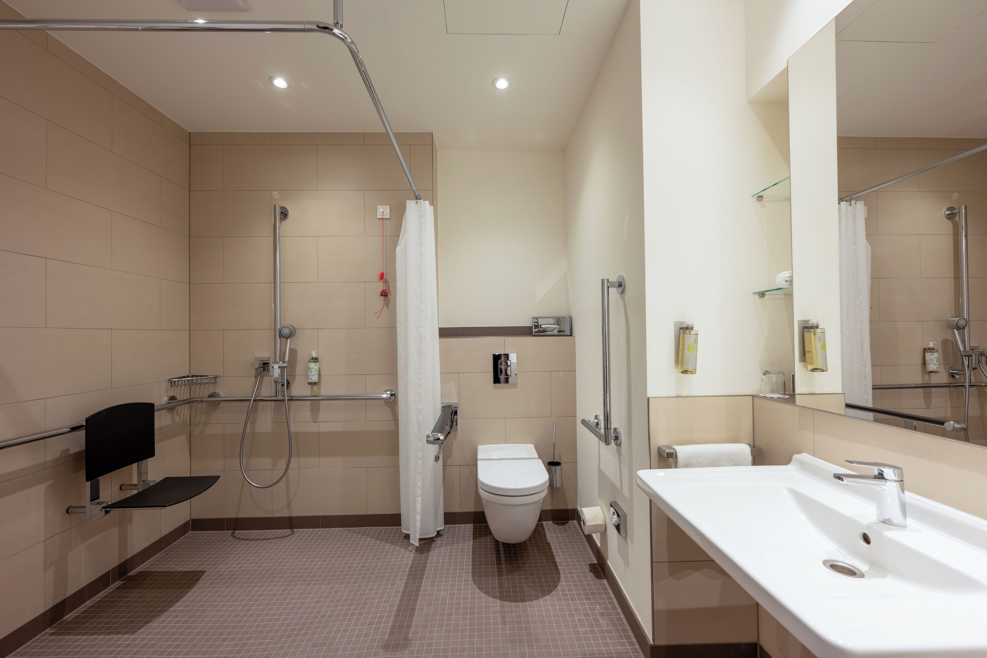 Un baño moderno con ducha, inodoro y lavamanos.